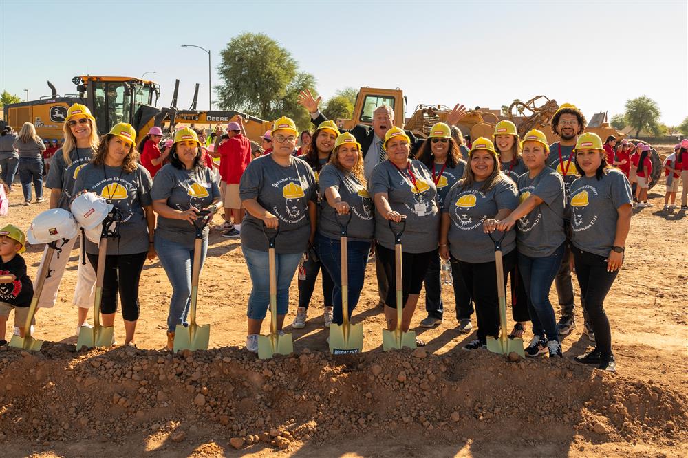 People wearing a Galveston Elementary shirt and posing for a photo. The shirt has the Galveston lion logo with a construction hat on top